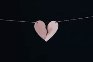 Broken paper heart on a string. Infidelity