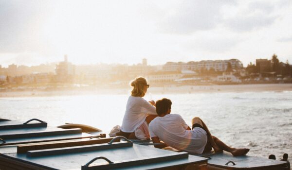 Australian couple sitting by a seawall in Sydney, Australia; locate birth parents in Australia