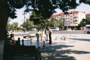 group of old Azerbaijanis playing giant chess in a park; locate birth parents in Azerbaijan concept