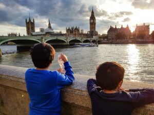 two English kids looking at the Big Ben during sunset; locate birth parents in the United Kingdom concept