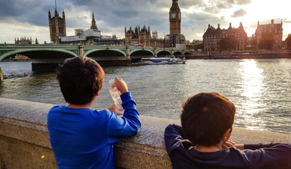 two English kids looking at the Big Ben during sunset; locate birth parents in the United Kingdom concept