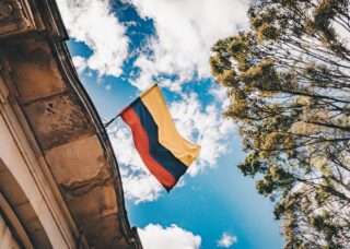 low angle shot of a Colombian flag in a building; skip tracing services in Colombia concept