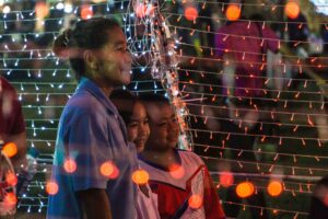 Thai mother posing with her two kids with lights around; locate birth parents in Thailand concept