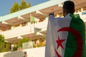 man wearing the Algerian flagon his back; skip tracing services in Algeria