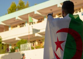 man wearing the Algerian flagon his back; skip tracing services in Algeria