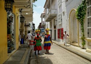 Colombian mothers wearing traditional Colombian clothes walking along the street; locate birth parents in Colombia concept