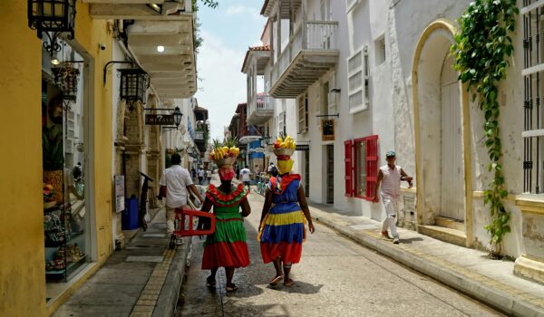 Colombian mothers wearing traditional Colombian clothes walking along the street; locate birth parents in Colombia concept