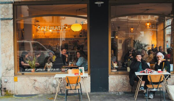 front of a cafe showing couples dining; locate birth parents in Belgium concept