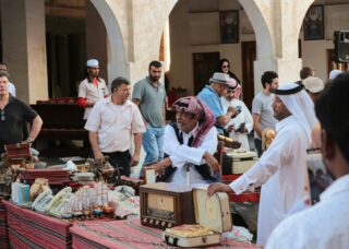 market in daytime with people selling in Doha, Qatar; locate birth parents in Qatar concept