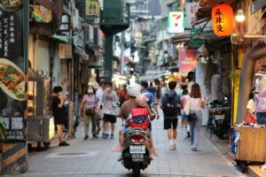 father and daughter riding a scooter in the streets of Taiwan; locate birth parents in Taiwan concept