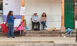 family sitting outside their house with a kid climbing the stairs; locate birthparents in Chile concept