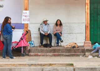 family sitting outside their house with a kid climbing the stairs; locate birthparents in Chile concept