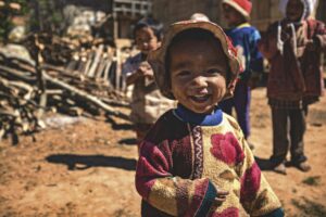 Burmese kid smiling and two kids at the back; locate birth parents in Myanmar concept