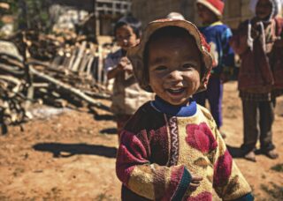 Burmese kid smiling and two kids at the back; locate birth parents in Myanmar concept