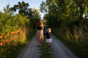 Swedish mother and daughter walking on dirt road in rural Sweden; locate birth parents in Sweden concept