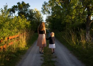 Swedish mother and daughter walking on dirt road in rural Sweden; locate birth parents in Sweden concept