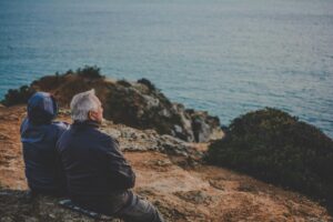 Portuguese grandparents sitting by the shore; locate birth parents in Portugal concept