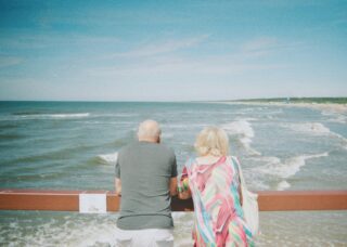 old couple looking at the sea in Palanga City Municipality, Lithuania; locate birth parents in Lithuania concept