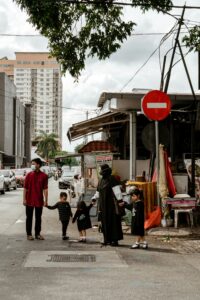 Malaysian family of 5 about to cross the street; locate birth parents in Malaysia concept