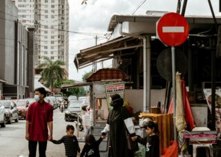 Malaysian family of 5 about to cross the street; locate birth parents in Malaysia concept