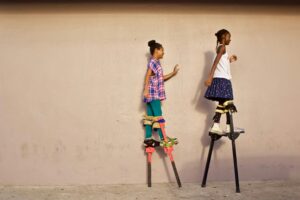 two Trini girls walking on stilts; locate birth parents in Trinidad and Tobago concept