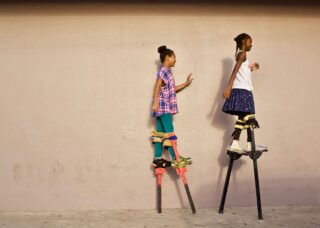 two Trini girls walking on stilts; locate birth parents in Trinidad and Tobago concept